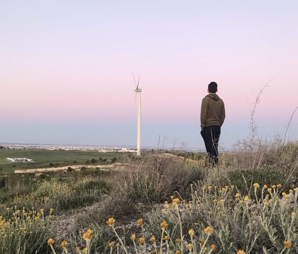 Me, yemenaris, gazing the city fear away from the hill during the sunset. At the background there is also a wind energy fan